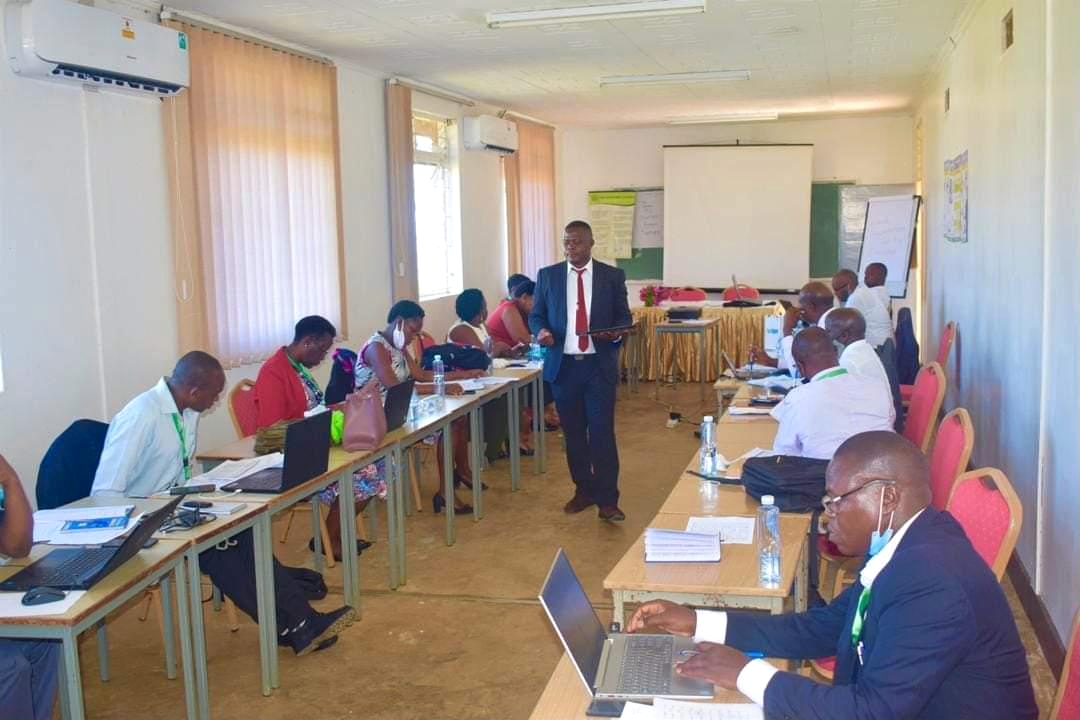 Enumerators seated along a long table during a training and tool testing session